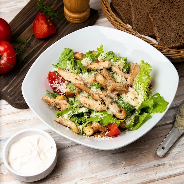 Niki's Caesar salad with grilled chicken, lettuce, tomatoes, croutons, and parmesan cheese.